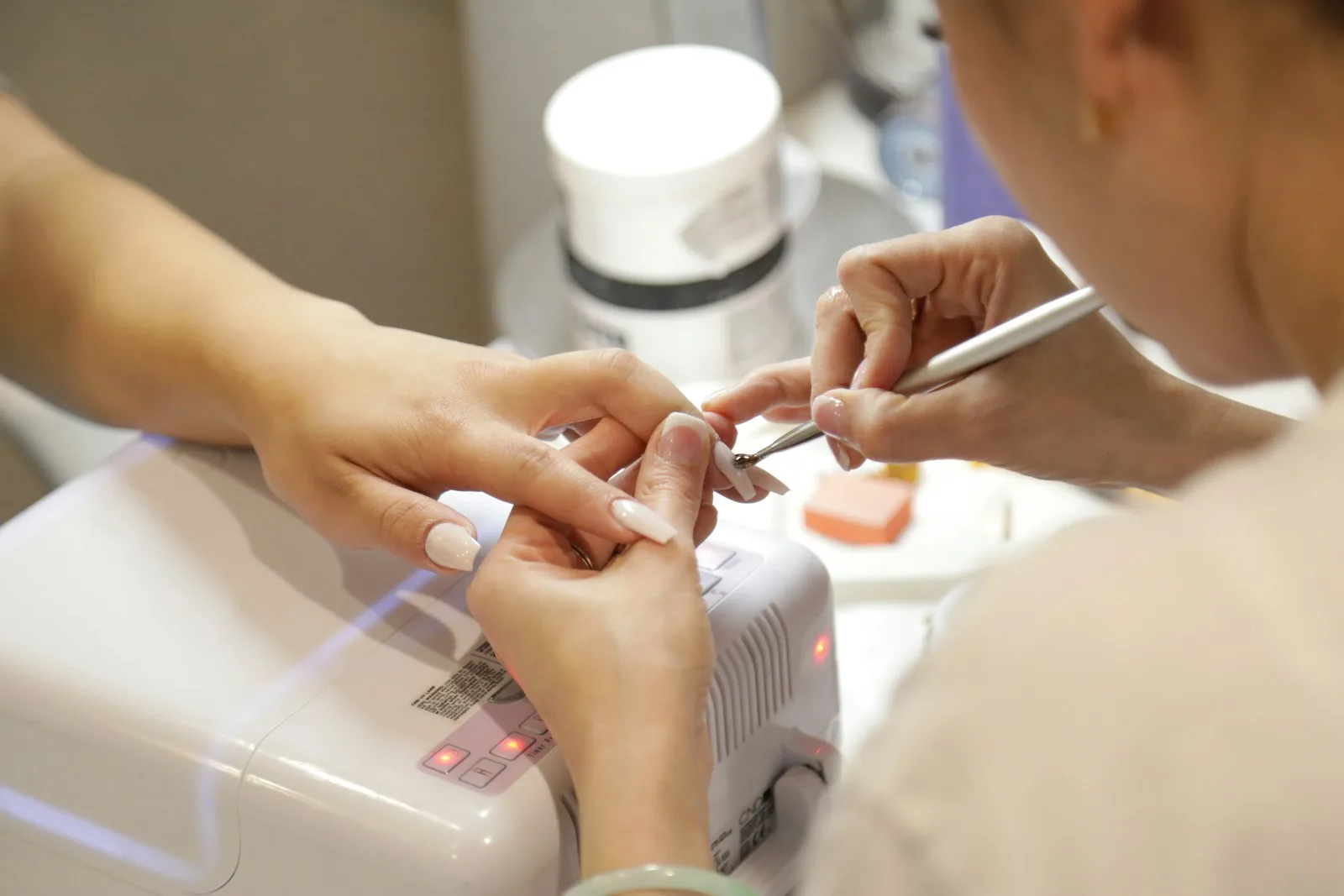 Profesional realizando una manicura semipermanente a una clienta