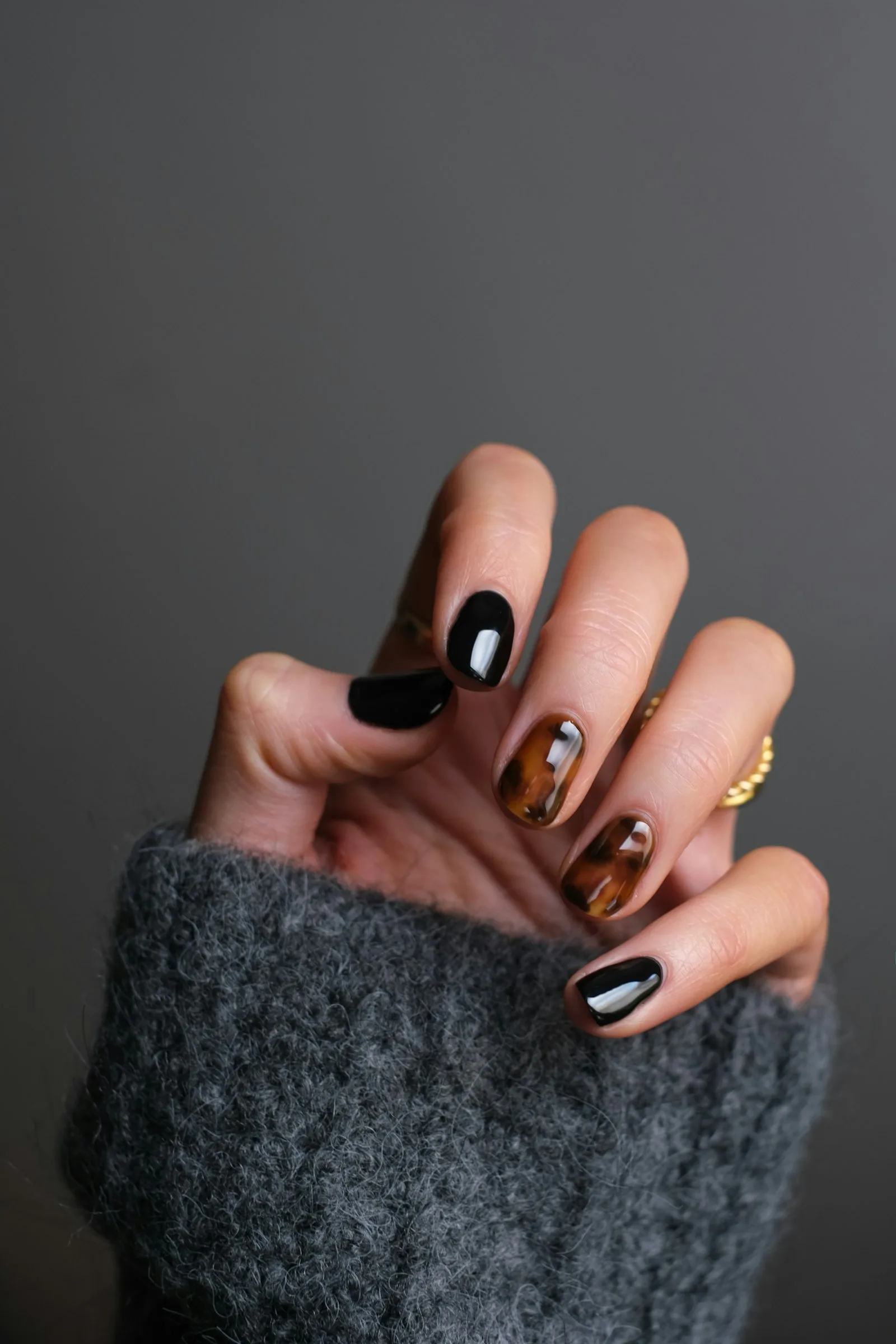 Mano con manicura elegante y jersey acogedor, ambiente de casa